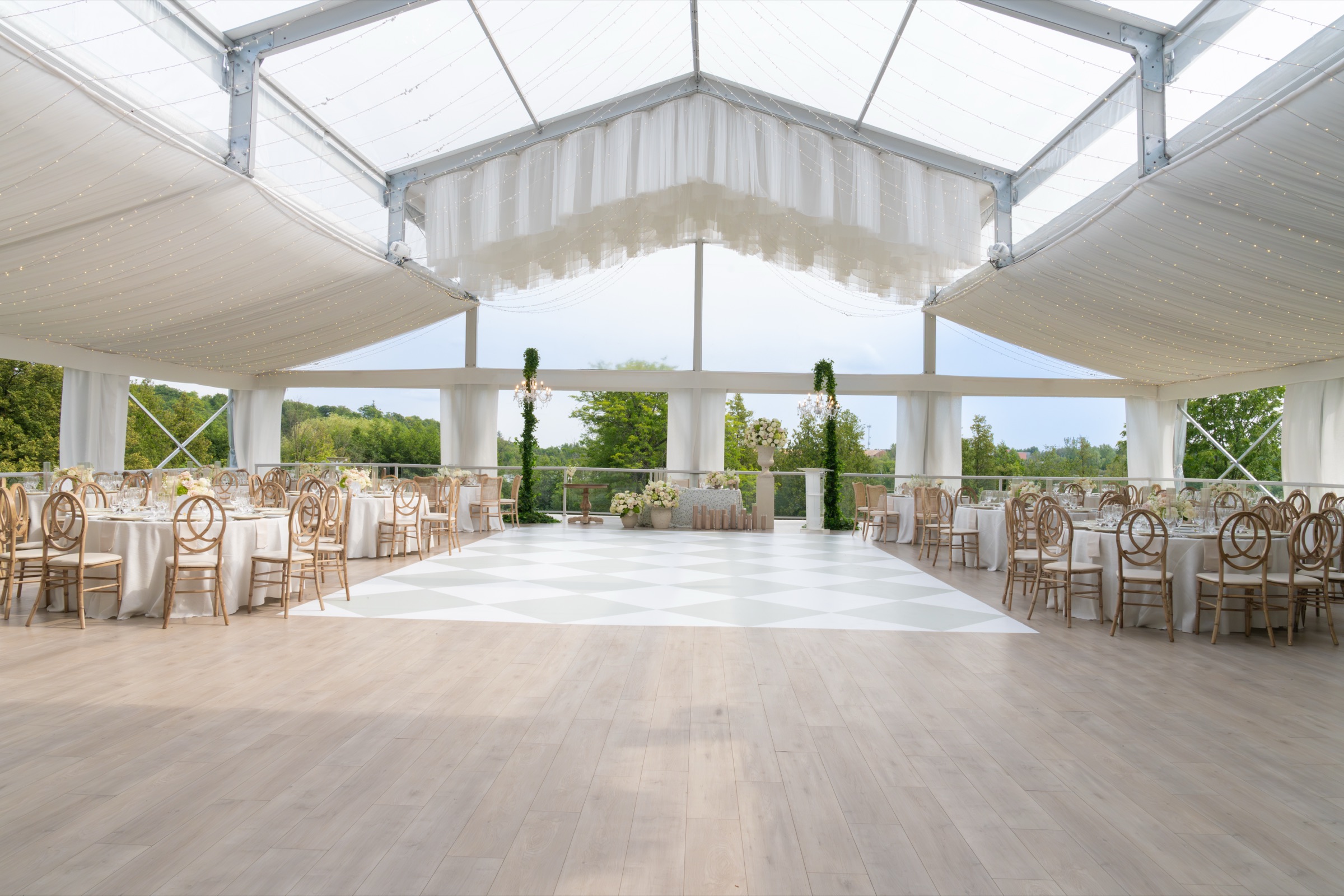 The Eaton Hall tent with topiary arches along its open side and the lake beyond