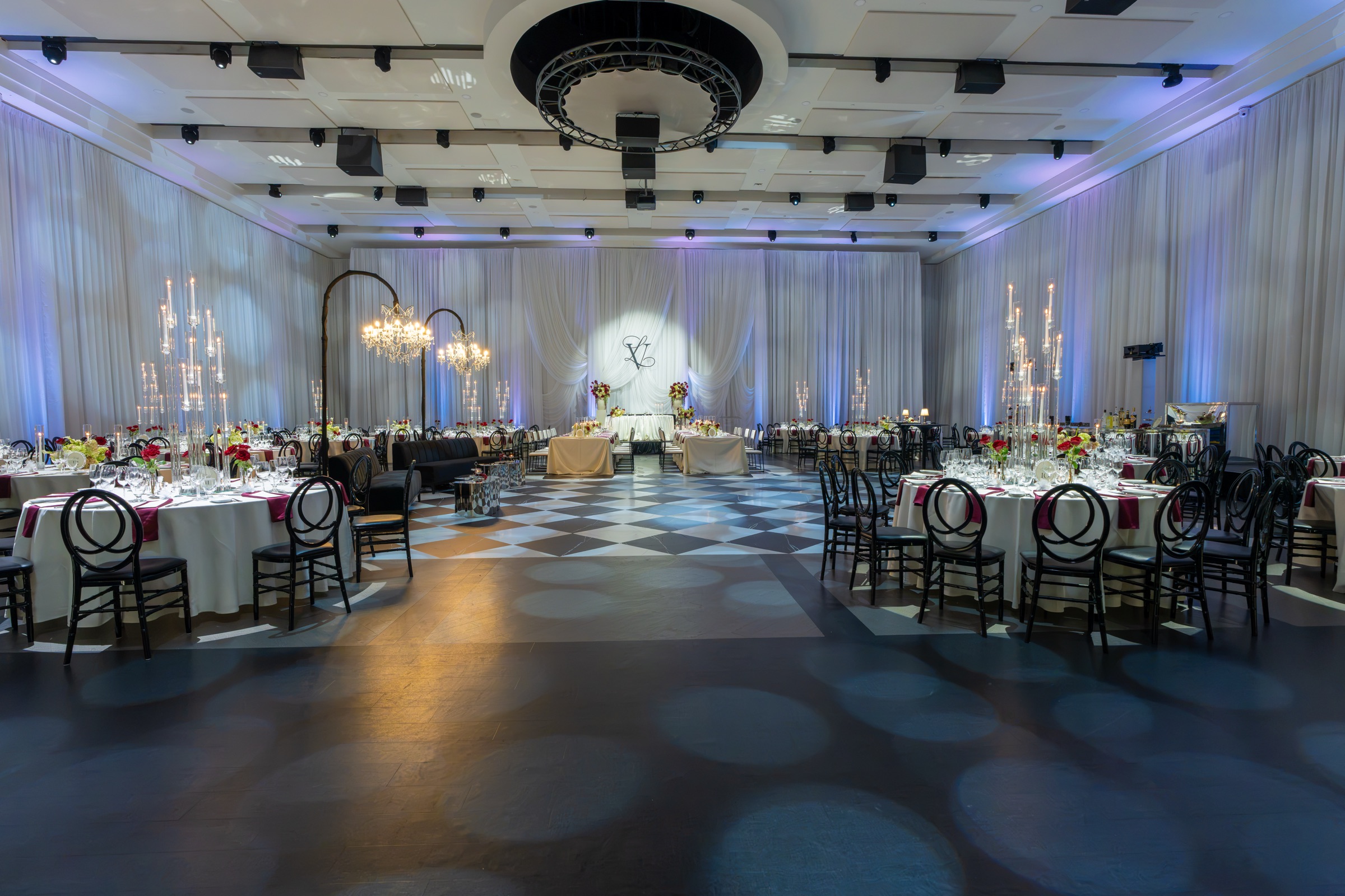 The Paramount ballroom with round tables, glass candelabra and violet-lit draping